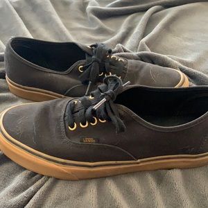 Black Vans with 5 gold eyelets